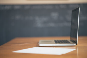 Macbook in front of blackboard